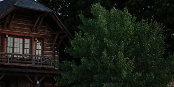 Movie still from “Yellowstone” (2018), created by John Linson – A log cabin sitting next to a large tree; Extreme Wide shot, Low angle