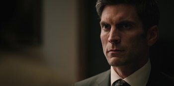 Movie still from “Yellowstone” (2018), created by John Linson – A man in a suit and tie; Close Up shot, Over the shoulder angle