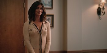 Movie still from “Yellowstone” (2018), created by John Linson – A woman standing in front of a wall with pictures on the wall; Medium shot, Over the shoulder angle