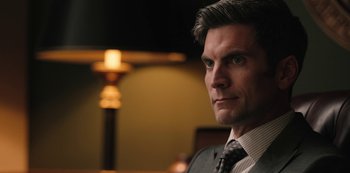 Movie still from “Yellowstone” (2018), created by John Linson – A man in a suit and a tie; Close Up shot, Over the shoulder angle