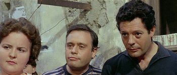 Movie still from “Yesterday, Today and Tomorrow” (1963), directed by Vittorio De Sica – Two men standing next to each other in front of a wall; Close Up shot, High angle