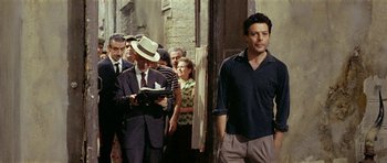 Movie still from “Yesterday, Today and Tomorrow” (1963), directed by Vittorio De Sica – A group of men standing next to each other on a street; Medium shot, Over the shoulder angle