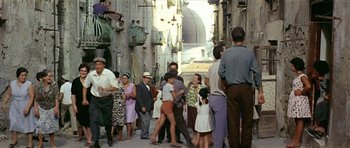Movie still from “Yesterday, Today and Tomorrow” (1963), directed by Vittorio De Sica – A group of people standing on the side of a street; Wide shot, High angle