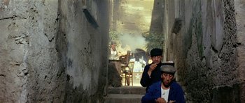 Movie still from “Yesterday, Today and Tomorrow” (1963), directed by Vittorio De Sica – A group of men sitting on steps eating food; Wide shot, High angle