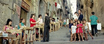 Movie still from “Yesterday, Today and Tomorrow” (1963), directed by Vittorio De Sica – A group of people sitting at tables on a sidewalk; Wide shot, High angle