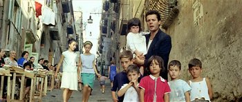 Movie still from “Yesterday, Today and Tomorrow” (1963), directed by Vittorio De Sica – A group of people walking down a street; Wide shot, High angle