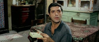Movie still from “Yesterday, Today and Tomorrow” (1963), directed by Vittorio De Sica – A man holding a box in his hands; Close Up shot, Low angle