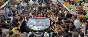 Movie still from “Yesterday, Today and Tomorrow” (1963), directed by Vittorio De Sica – A crowd of people gathered around an antique car; Extreme Wide shot, High angle