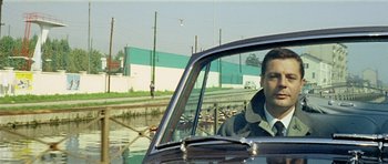 Movie still from “Yesterday, Today and Tomorrow” (1963), directed by Vittorio De Sica – A man sitting in the driver's seat of a car; Close Up shot, Low angle