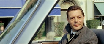 Movie still from “Yesterday, Today and Tomorrow” (1963), directed by Vittorio De Sica – A man in a suit and tie in front of a building; Close Up shot, Low angle