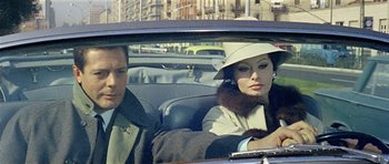 Movie still from “Yesterday, Today and Tomorrow” (1963), directed by Vittorio De Sica – A man and a woman sitting in the back seat of a car; Medium shot, Over the shoulder angle