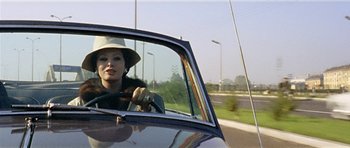 Movie still from “Yesterday, Today and Tomorrow” (1963), directed by Vittorio De Sica – A woman in a hat driving a car on the road; Close Up shot, Low angle