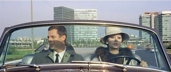Movie still from “Yesterday, Today and Tomorrow” (1963), directed by Vittorio De Sica – A man and a woman sitting in the back seat of a car; Medium shot, Over the shoulder angle