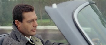 Movie still from “Yesterday, Today and Tomorrow” (1963), directed by Vittorio De Sica – A person sitting in a car with an umbrella; Close Up shot, Over the shoulder angle