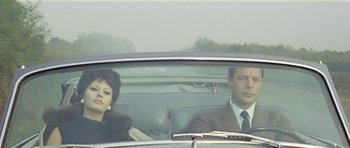 Movie still from “Yesterday, Today and Tomorrow” (1963), directed by Vittorio De Sica – A man and a woman sitting in the back of a car; Medium shot, High angle