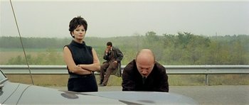 Movie still from “Yesterday, Today and Tomorrow” (1963), directed by Vittorio De Sica – A man and a woman sitting next to each other on the side of a road; Medium shot, Over the shoulder angle