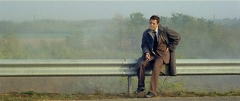 Movie still from “Yesterday, Today and Tomorrow” (1963), directed by Vittorio De Sica – A man sitting on top of a wooden bench; Wide shot, Low angle