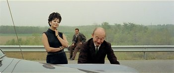 Movie still from “Yesterday, Today and Tomorrow” (1963), directed by Vittorio De Sica – A man and a woman sitting next to each other on the side of a road; Medium shot, Over the shoulder angle