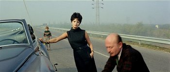 Movie still from “Yesterday, Today and Tomorrow” (1963), directed by Vittorio De Sica – A woman standing next to a man on the side of a road; Medium shot, Over the shoulder angle