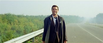 Movie still from “Yesterday, Today and Tomorrow” (1963), directed by Vittorio De Sica – A man in a suit and tie standing next to a bridge; Medium shot, Low angle