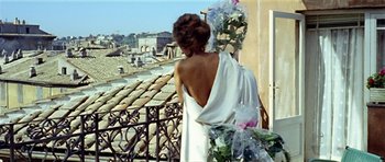 Movie still from “Yesterday, Today and Tomorrow” (1963), directed by Vittorio De Sica – A woman standing on a balcony looking out at a city; Medium shot, Low angle