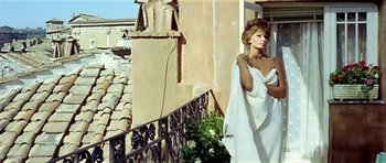 Movie still from “Yesterday, Today and Tomorrow” (1963), directed by Vittorio De Sica – A woman wrapped in a white towel standing next to a building; Medium shot, Low angle