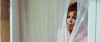 Movie still from “Yesterday, Today and Tomorrow” (1963), directed by Vittorio De Sica – A woman smoking a cigarette while looking out of a window; Close Up shot, Low angle