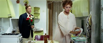 Movie still from “Yesterday, Today and Tomorrow” (1963), directed by Vittorio De Sica – A man and a woman standing in front of a table; Medium shot, Over the shoulder angle