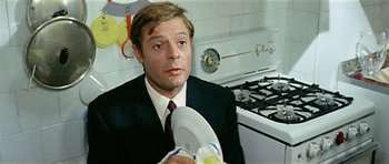 Movie still from “Yesterday, Today and Tomorrow” (1963), directed by Vittorio De Sica – A man in a suit holding a plate in a kitchen; Close Up shot, High angle