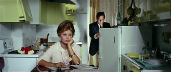 Movie still from “Yesterday, Today and Tomorrow” (1963), directed by Vittorio De Sica – A man and a woman are sitting at a kitchen table; Medium shot, Over the shoulder angle