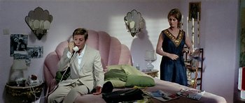 Movie still from “Yesterday, Today and Tomorrow” (1963), directed by Vittorio De Sica – A man and a woman sitting on a pink couch; Medium shot, High angle