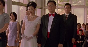 Movie still from “Yi Yi” (2000), directed by Edward Yang – A man and a woman standing next to each other in formal wear; Medium shot, Low angle