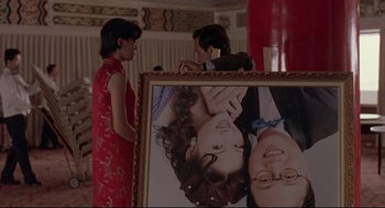 Movie still from “Yi Yi” (2000), directed by Edward Yang – Two people standing in front of a picture of a couple; Close Up shot, Over the shoulder angle