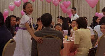 Movie still from “Yi Yi” (2000), directed by Edward Yang – A group of people sitting at a table with pink balloons; Medium shot, Over the shoulder angle