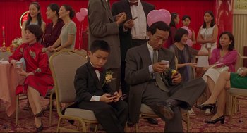 Movie still from “Yi Yi” (2000), directed by Edward Yang – A group of people sitting in chairs looking at cell phones; Wide shot, High angle