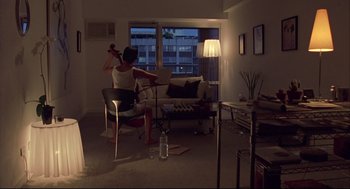 Movie still from “Yi Yi” (2000), directed by Edward Yang – A woman sitting on a chair in a living room; Wide shot, High angle