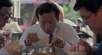 Movie still from “Yi Yi” (2000), directed by Edward Yang – A man in a white shirt and a tie stirring something with chopsticks; Close Up shot, Low angle