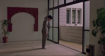 Movie still from “Yi Yi” (2000), directed by Edward Yang – A man standing in a room looking out a window; Wide shot, High angle