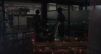 Movie still from “Yi Yi” (2000), directed by Edward Yang – Two people are standing in a room looking out of a window at night; Extreme Wide shot, Over the shoulder angle