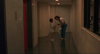 Movie still from “Yi Yi” (2000), directed by Edward Yang – A woman and a young girl are standing in a hallway; Wide shot, High angle