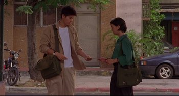 Movie still from “Yi Yi” (2000), directed by Edward Yang – A man and a woman standing next to each other on the sidewalk; Medium shot, High angle