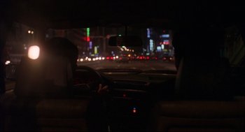 Movie still from “Yi Yi” (2000), directed by Edward Yang – A view from inside a car at night of the city lights; Wide shot, Over the shoulder angle