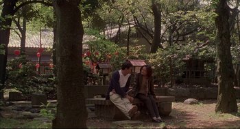 Movie still from “Yi Yi” (2000), directed by Edward Yang – A man and a woman sitting on a park bench; Wide shot, High angle