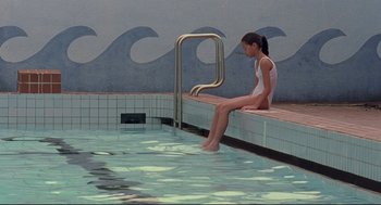 Movie still from “Yi Yi” (2000), directed by Edward Yang – A woman sitting on the edge of a swimming pool; Wide shot, High angle