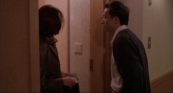 Movie still from “Yi Yi” (2000), directed by Edward Yang – A man and a woman standing next to each other in front of a door; Medium shot, Over the shoulder angle