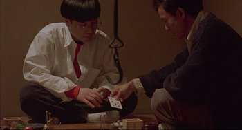 Movie still from “Yi Yi” (2000), directed by Edward Yang – Two people playing cards on a table; Medium shot, High angle