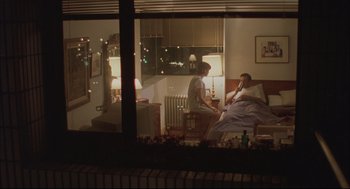 Movie still from “Yi Yi” (2000), directed by Edward Yang – A man and a woman sitting in a bed in front of a window; Wide shot, Over the shoulder angle
