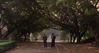 Movie still from “Yi Yi” (2000), directed by Edward Yang – Two men standing in the middle of a parking lot under a tree; Extreme Wide shot, High angle