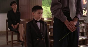 Movie still from “Yi Yi” (2000), directed by Edward Yang – A young boy in a tuxedo standing next to an older man; Medium shot, Over the shoulder angle