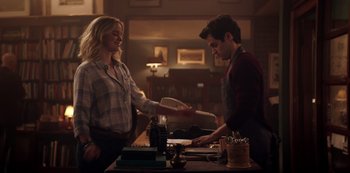 Movie still from “You” (2018), created by Sera Gamble – A man and a woman at a bar shaking hands; Medium shot, Over the shoulder angle